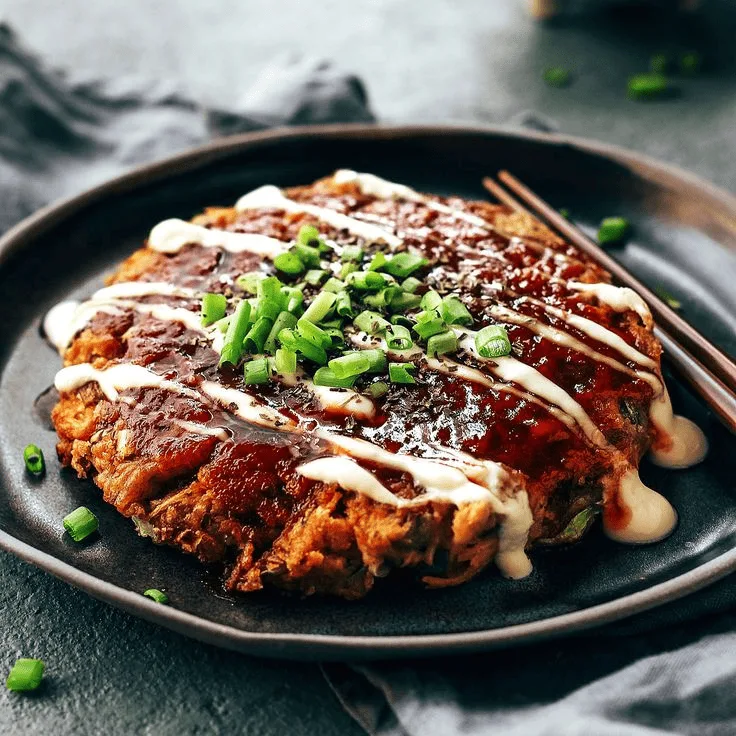 Окономияки — капустная лепёшка на гриле с беконом, овощами и соусом